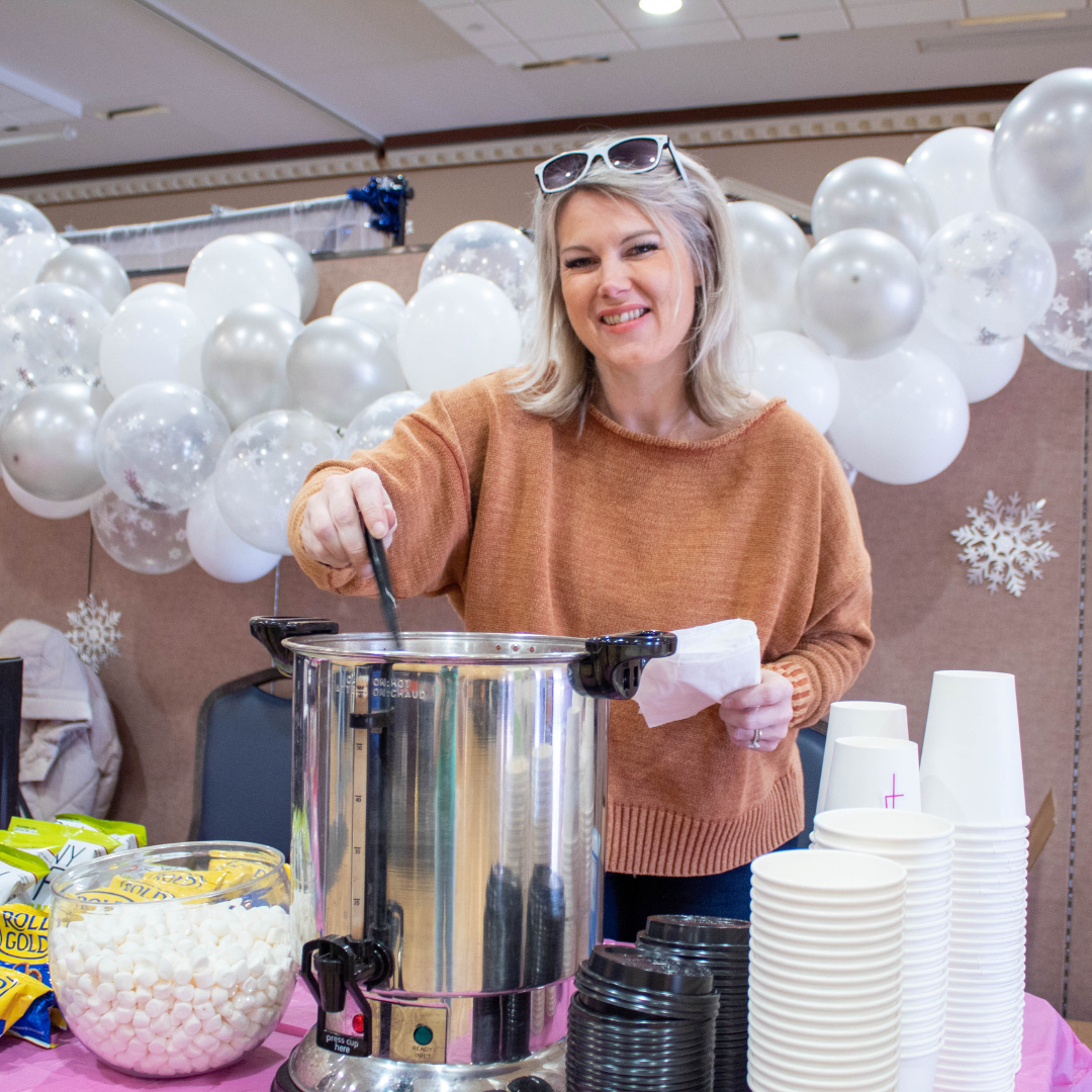 Girl serving hot chocolate at Winter Housing Fair
