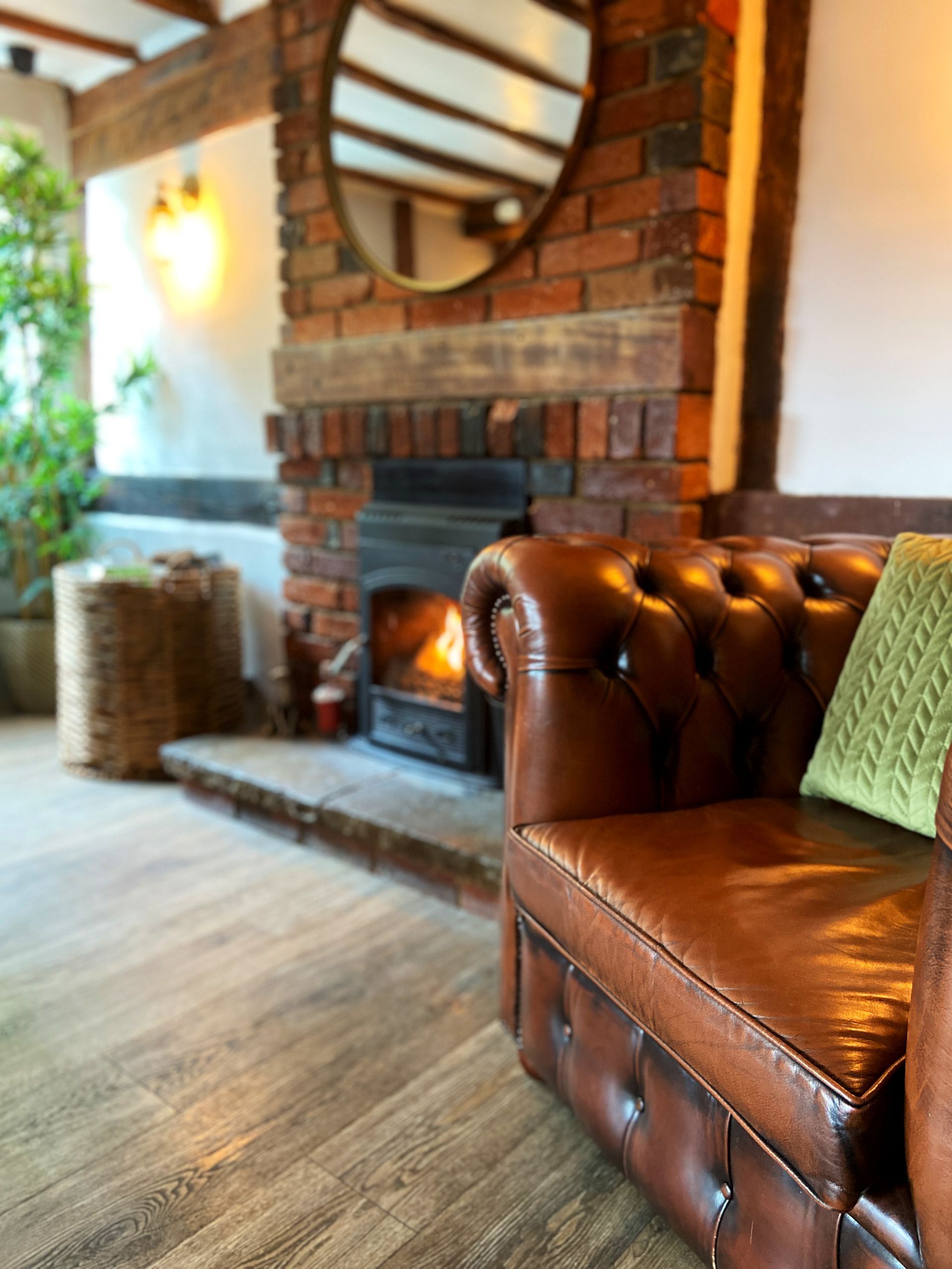leather armchair next to the log burner at The Fox and Hounds