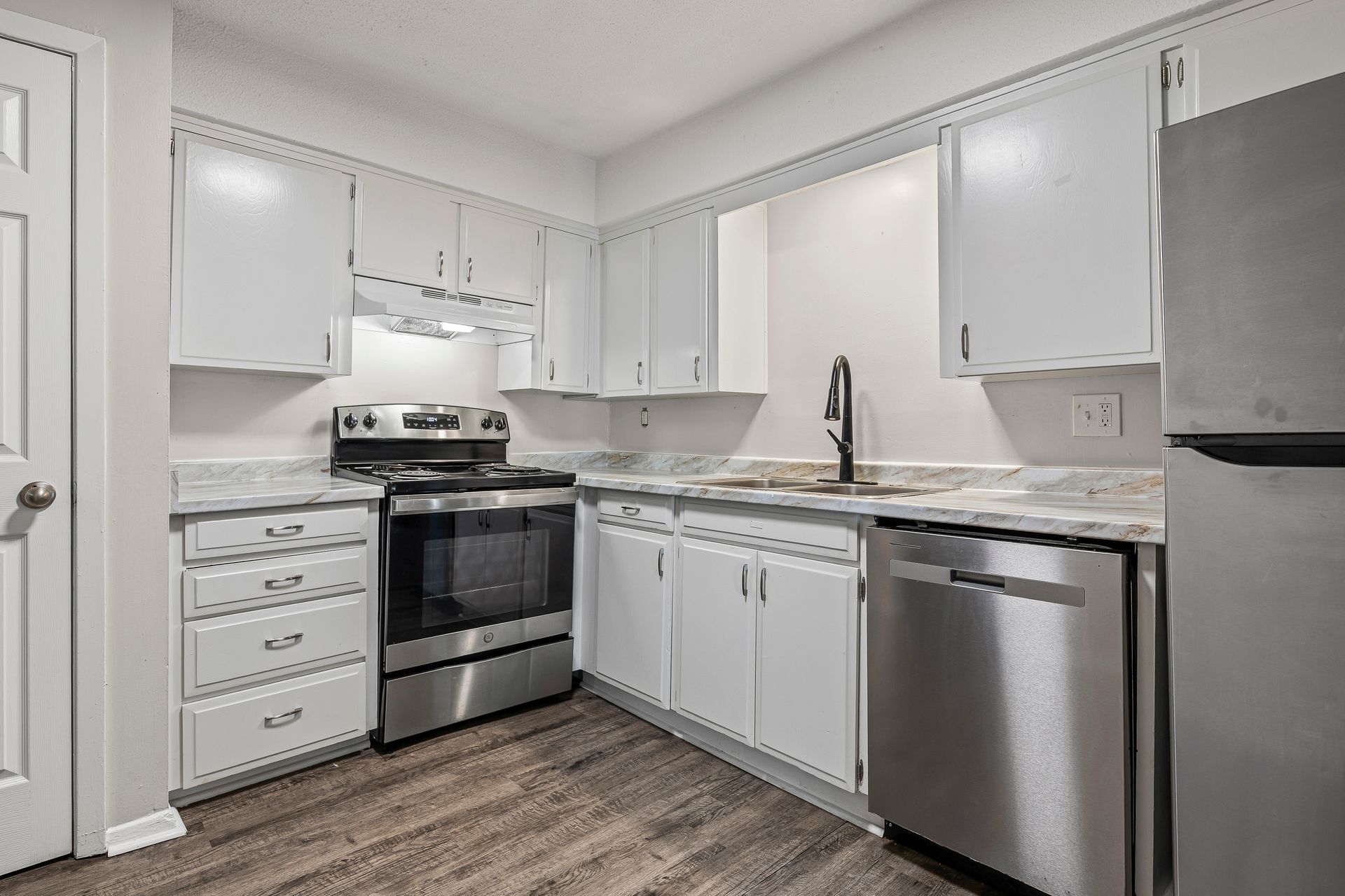 Kitchen with white cabinets, stainless steel appliances, and light countertops.