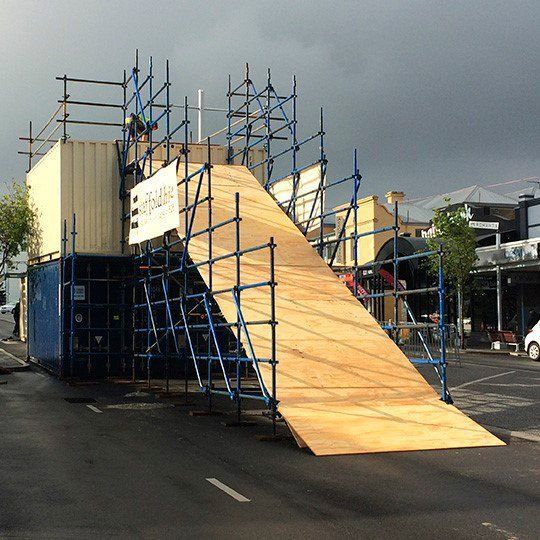 A large wooden ramp is being built in front of a building