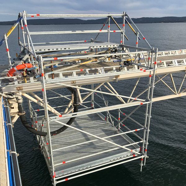 A dock with scaffolding and a hose attached to it