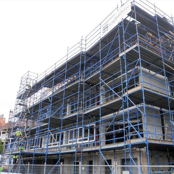 A building under construction with blue scaffolding around it