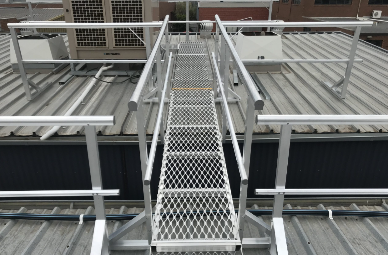 A crane is lifting a bridge over a building