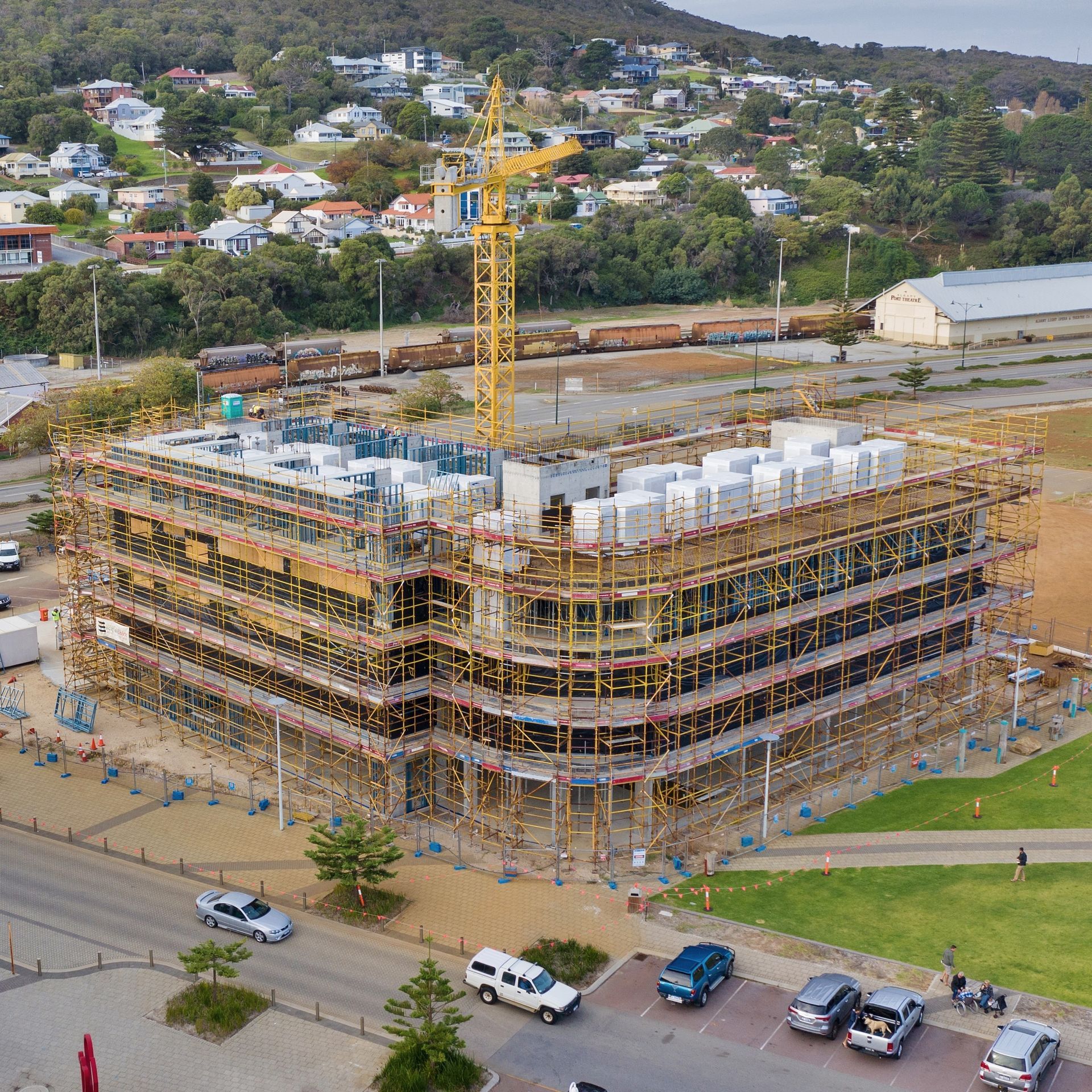 A truck is parked in front of a building covered in scaffolding.