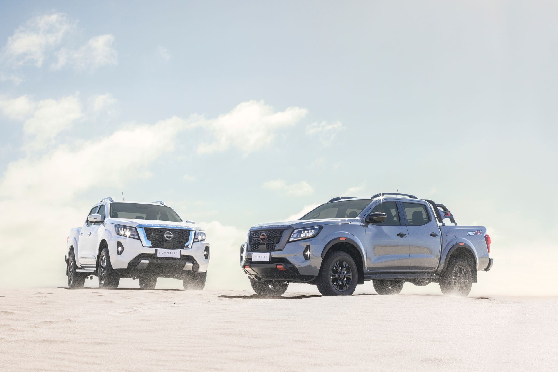 Uma caminhonete Nissan azul está dirigindo por uma estrada.