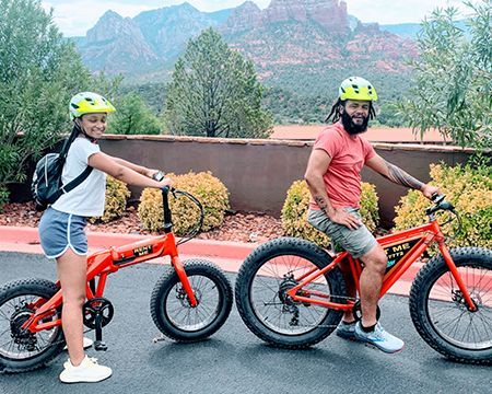 A man and a woman are riding bicycles on a road.