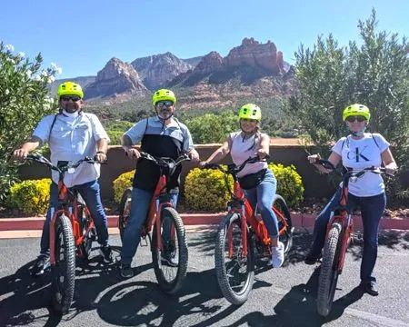 A group of people are standing next to each other on bicycles.