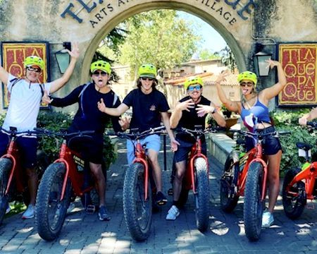 A group of people are standing next to each other on bicycles.