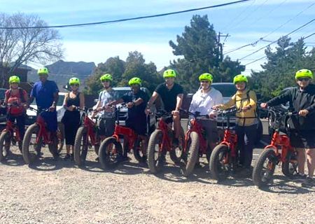 A group of people are standing next to each other on bicycles.