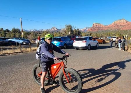 A man is riding an electric bike in a parking lot.