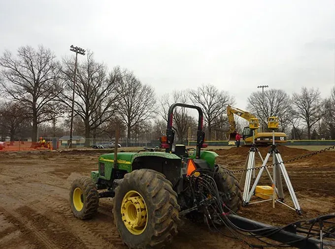 A yellow excavator is moving dirt on a construction site.