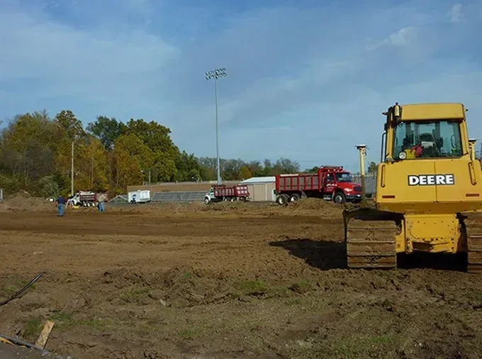 A yellow excavator is digging a hole in the ground.
