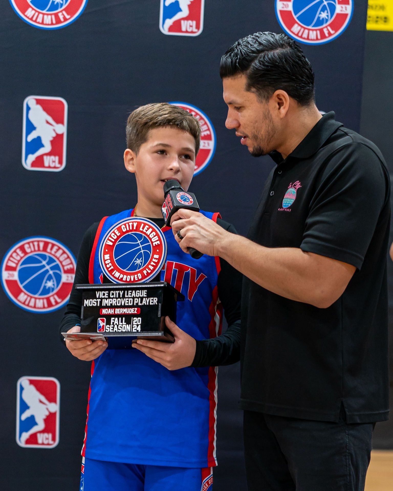 outh basketball player holding Most Improved Award at Vice City Basketball All-Star event.