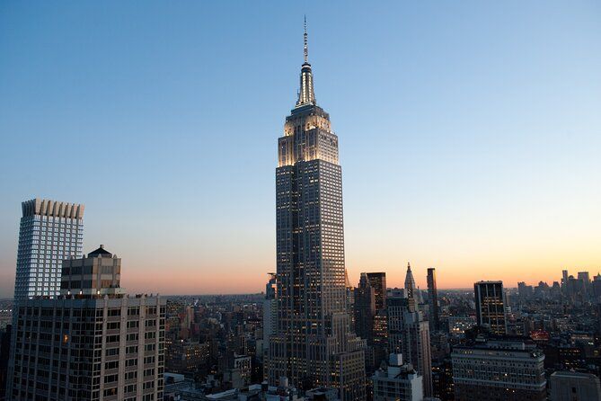 The empire state building is lit up at night in new york city.