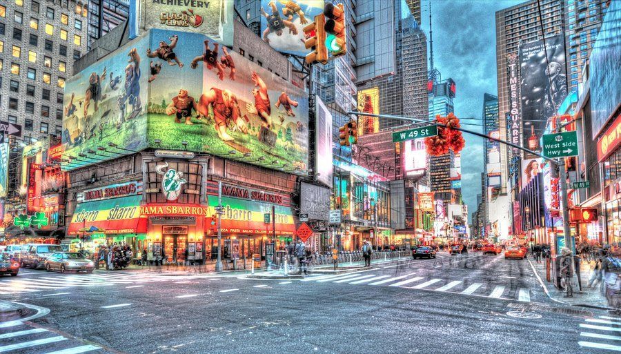 A city street with a lot of buildings and advertisements on the side of it.