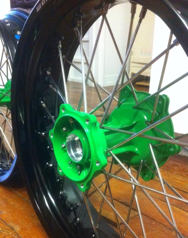 A close up of a motorcycle wheel with a green hub
