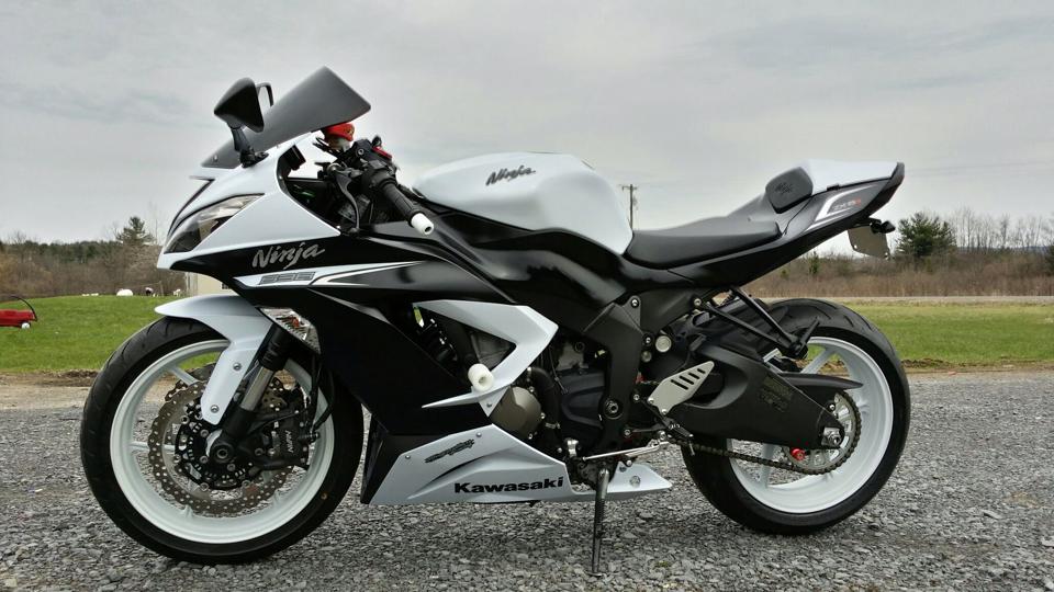 A black and white ninja motorcycle is parked on the side of the road
