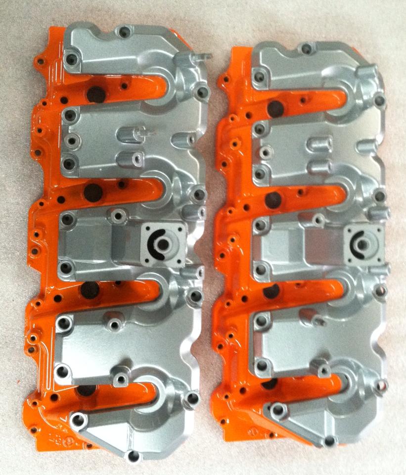 A pair of orange and silver engine covers on a table