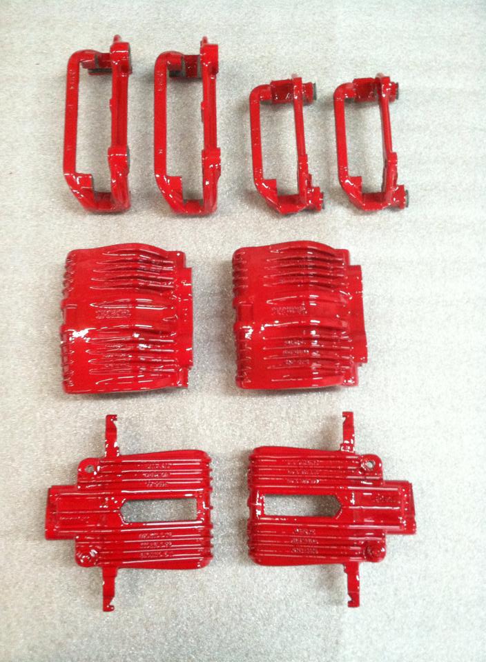 A set of red brake calipers on a white surface