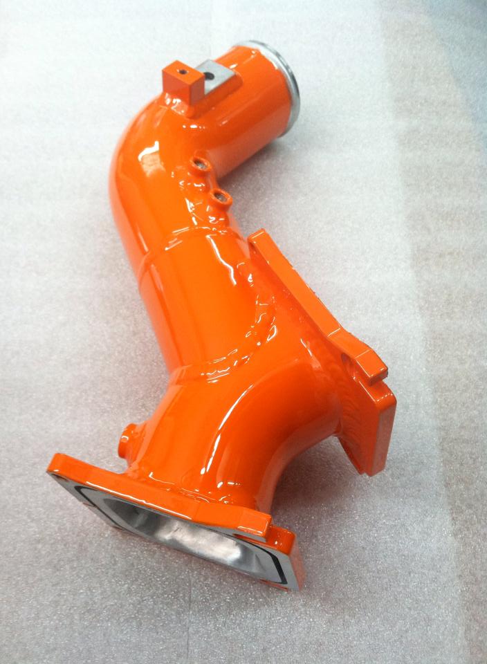 An orange pipe is sitting on a white surface
