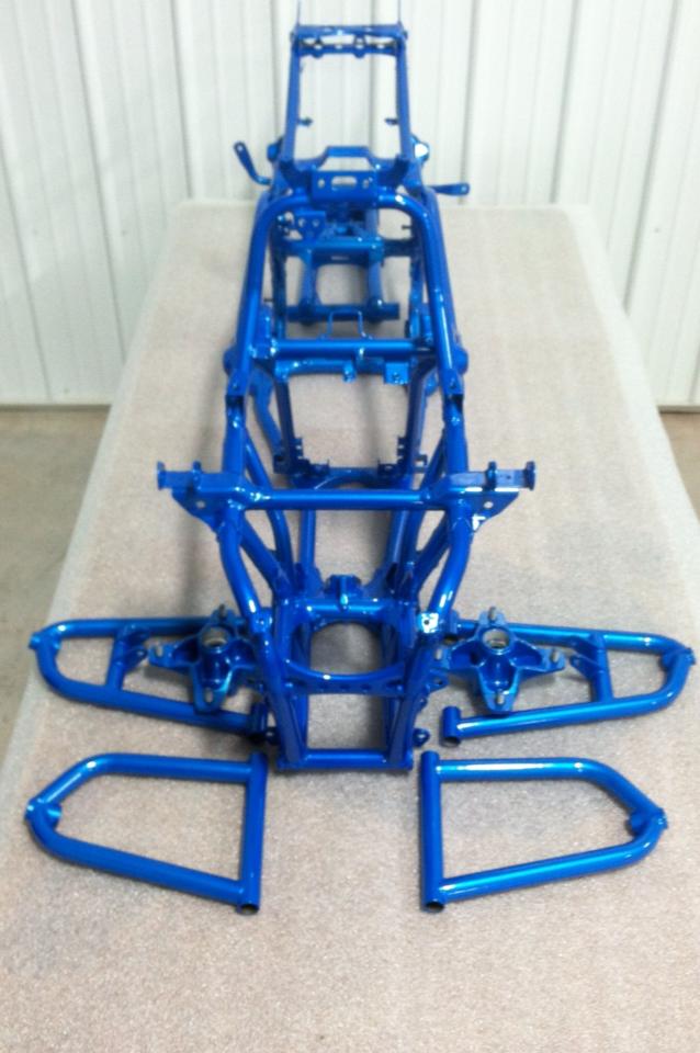 A blue motorcycle frame is sitting on a table