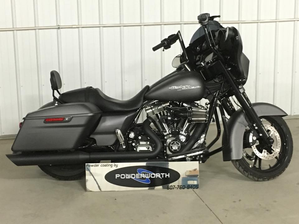 A harley davidson motorcycle is parked in front of a white wall.