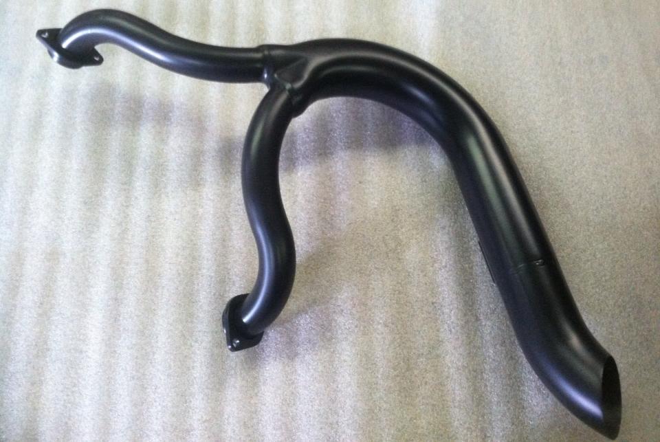 A black pipe is sitting on a white surface