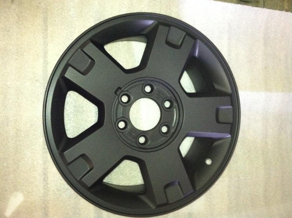 A close up of a black wheel on a white surface