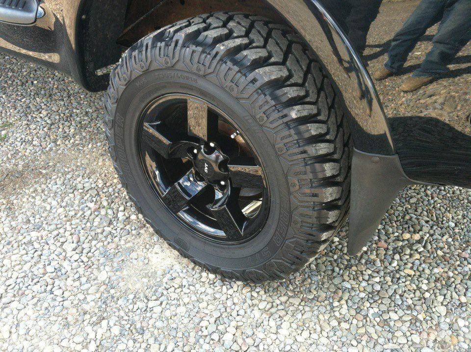 A close up of a tire on a black truck