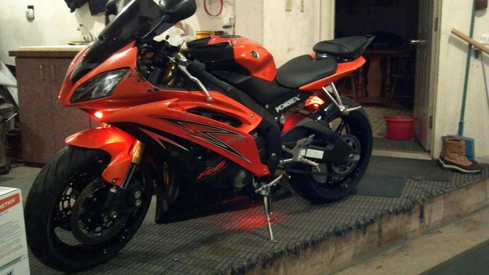 An orange yamaha motorcycle is parked in a garage