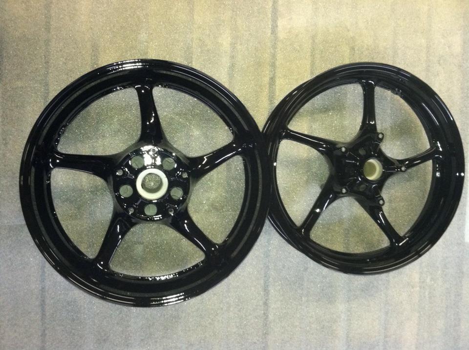 A pair of black motorcycle wheels on a table