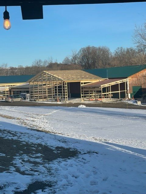 A snowy field with a building under construction in the background
