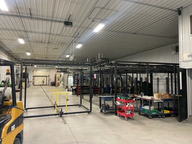 A large warehouse with a forklift in the middle of it.