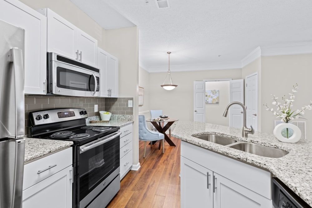 a kitchen with stainless steel appliances and granite counter tops at Marquis on Edwards Mill in Raleigh, NC. 