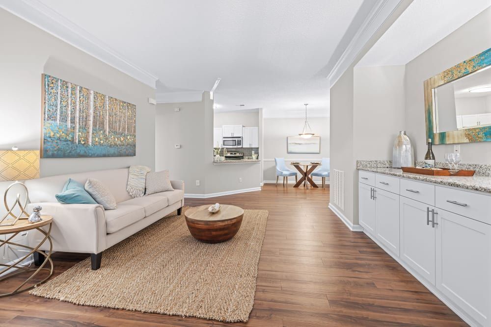 a living room with a couch, coffee table, and rug at Marquis on Edwards Mill in Raleigh, NC. 
