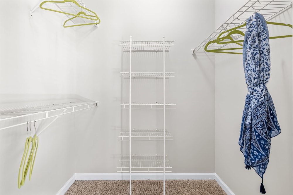 a walk-in closet with a blue and white scarf hanging on the wall at Marquis on Edwards Mill in Raleigh, NC. 