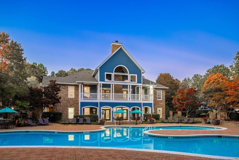 a large blue house with a large swimming pool in front of it at Marquis on Edwards Mill in Raleigh, NC. 