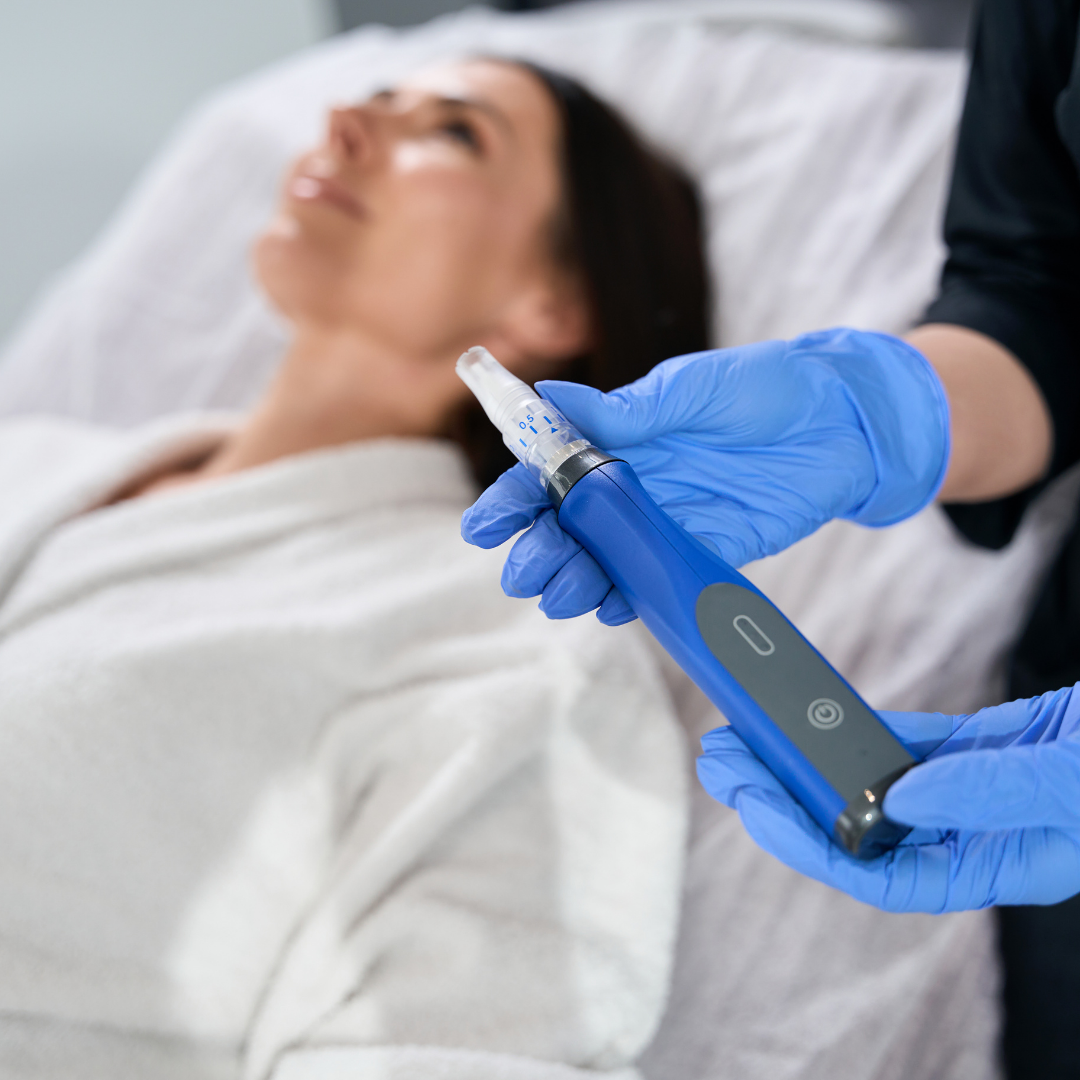 Eine Person mit blauen Handschuhen hält ein Gerät vor einer Frau , die im Bett liegt.