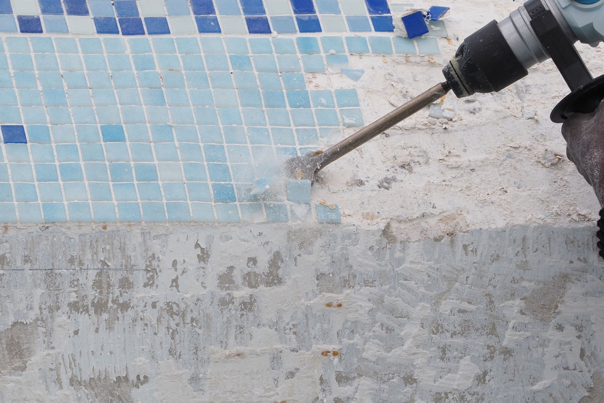Pool remodeling with tile removal during swimming pool repair.