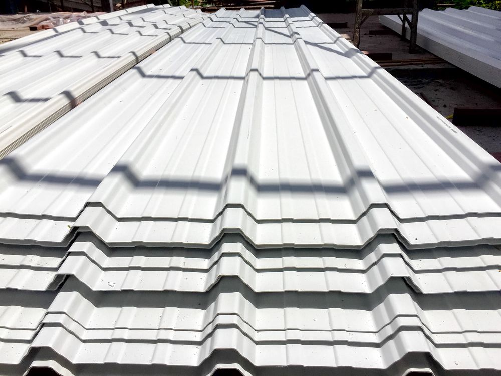 White corrugated metal roofing sheets stacked.