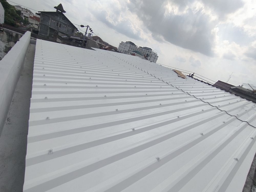 White corrugated metal roof under a cloudy sky.
