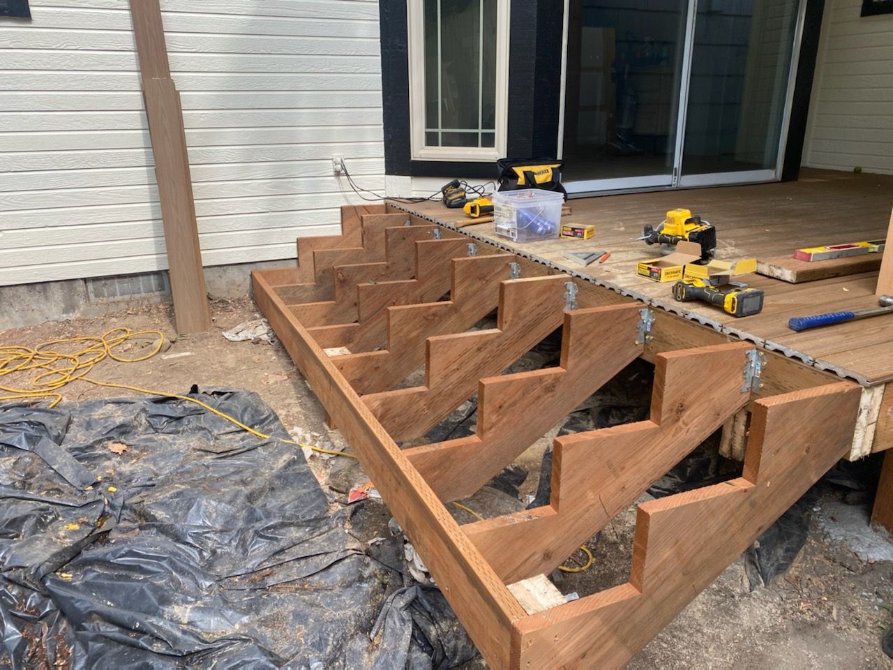 Deck stair repair project by A1 Handyman Boise, rebuilding damaged stringers and steps with high-quality redwood lumber.