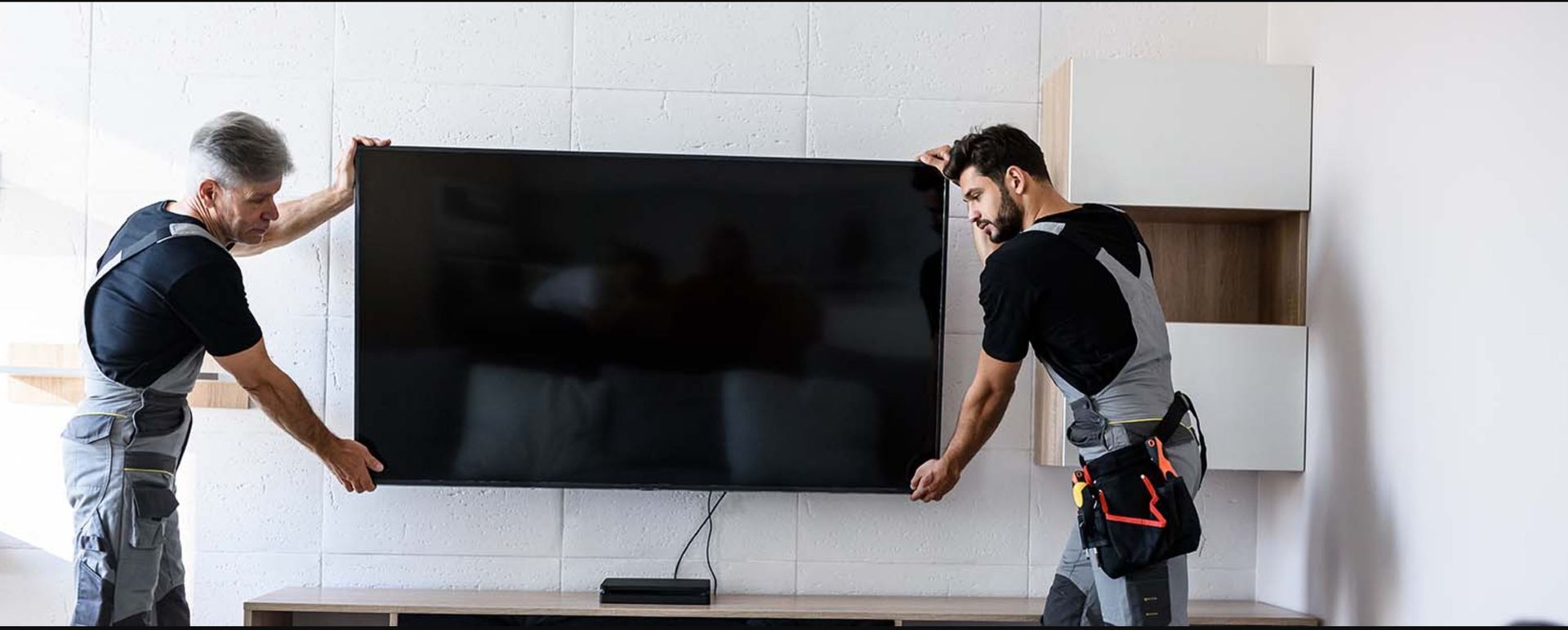 A1 Handyman Boise technicians professionally mounting a flat-screen TV on a living room wall for secure and clean installation.