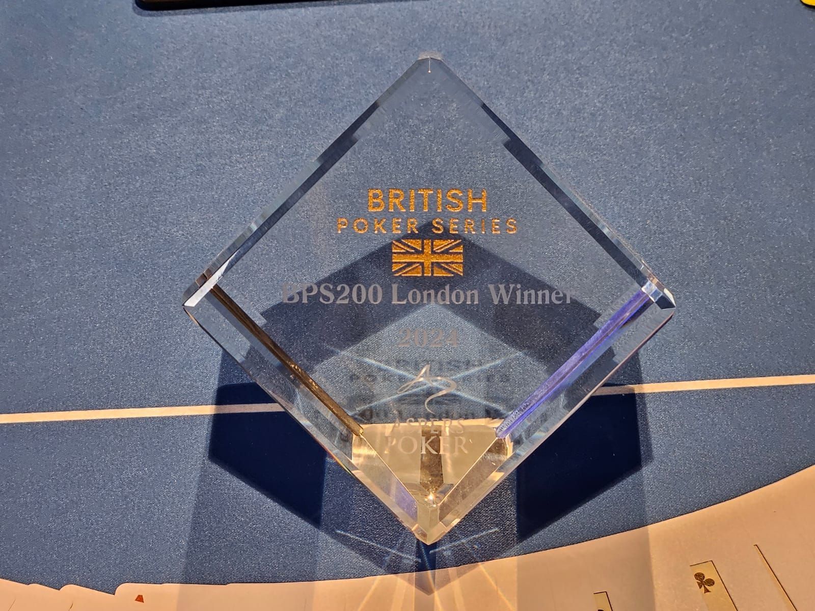 Clear, diamond-shaped trophy with gold text 