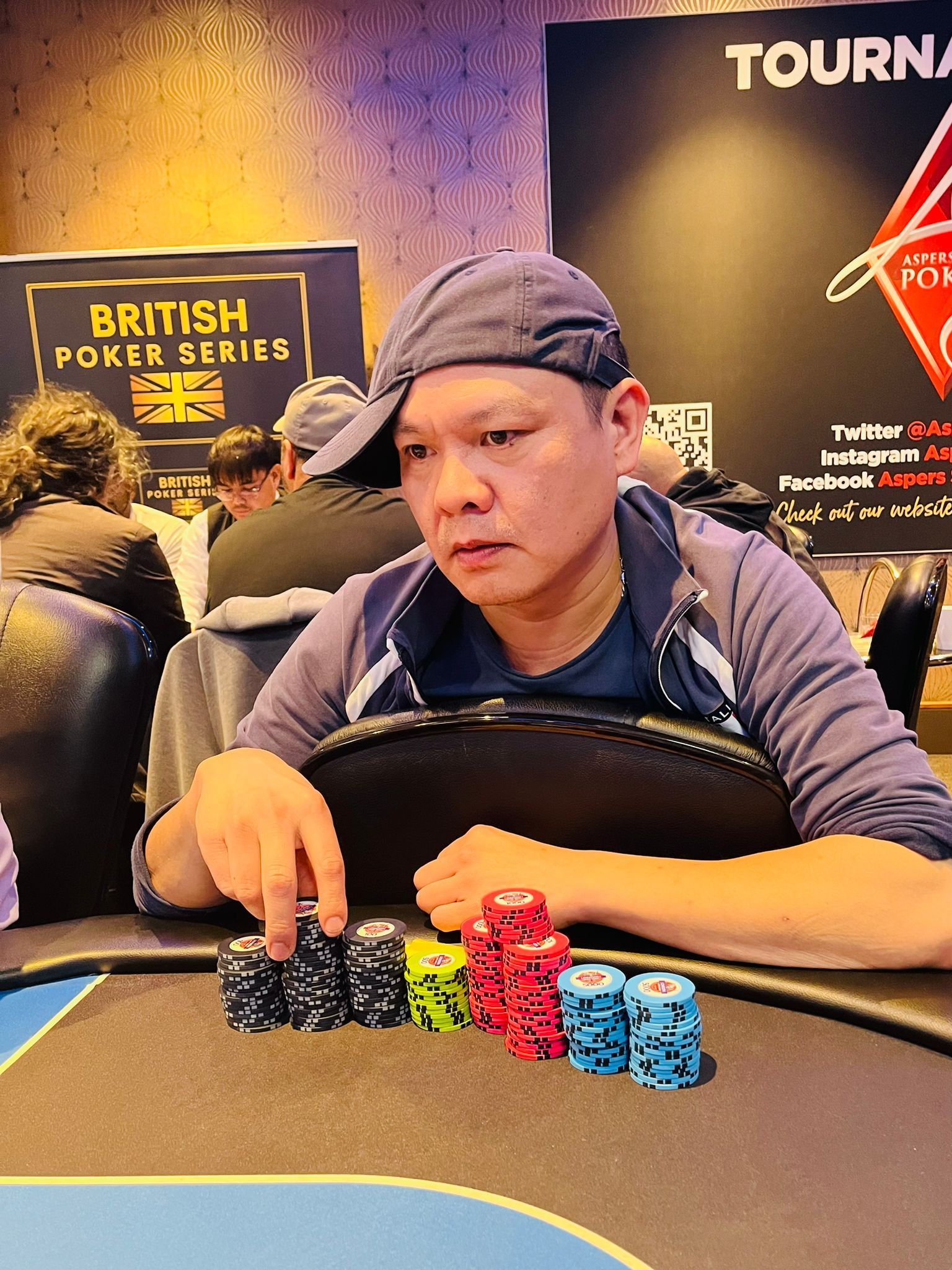 Man at poker table with stacks of chips.
