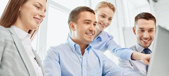 A group of business people are looking at a laptop computer.