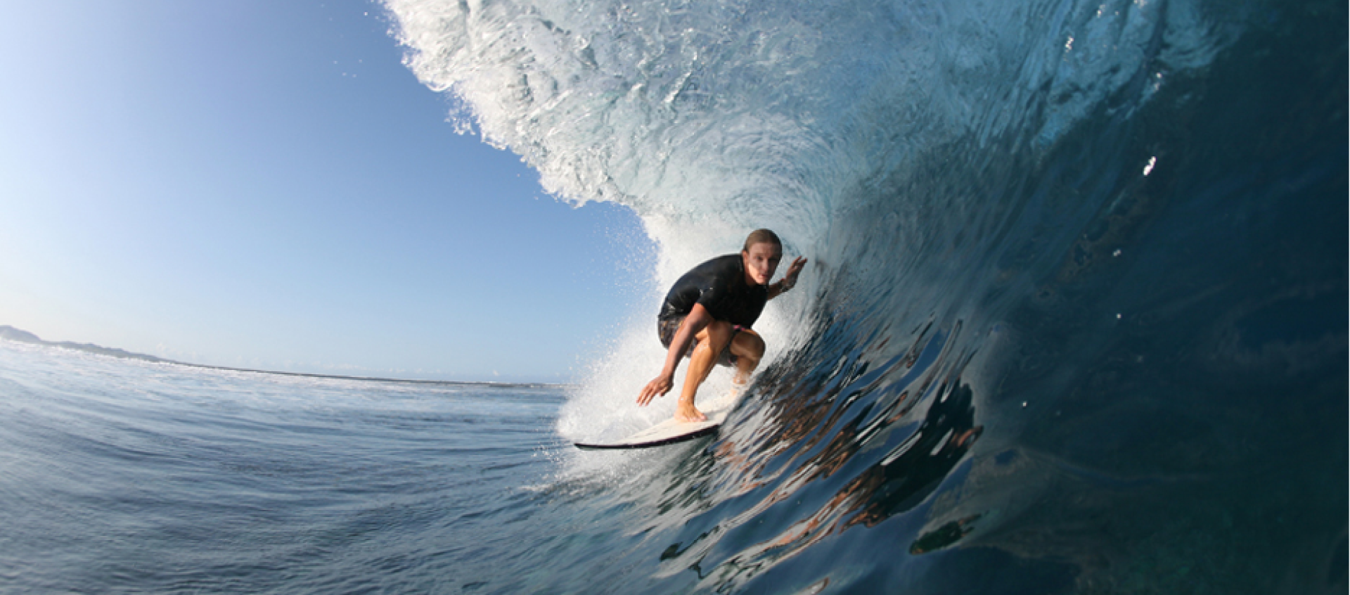 A man is riding a wave on a surfboard in the ocean.