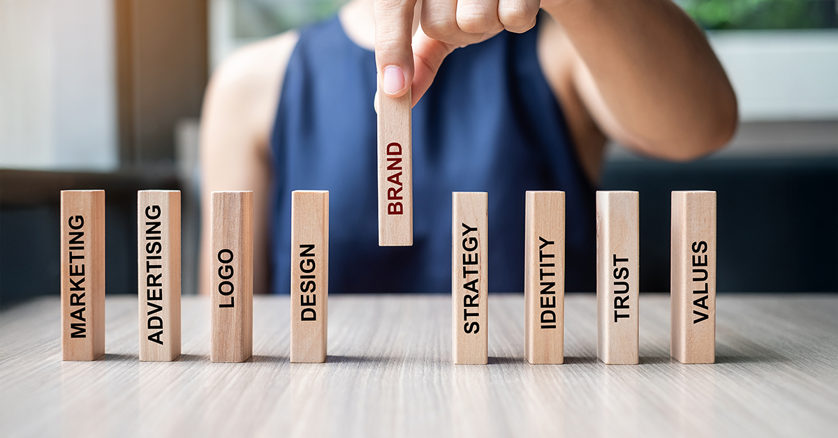 A hand places a wooden block labeled