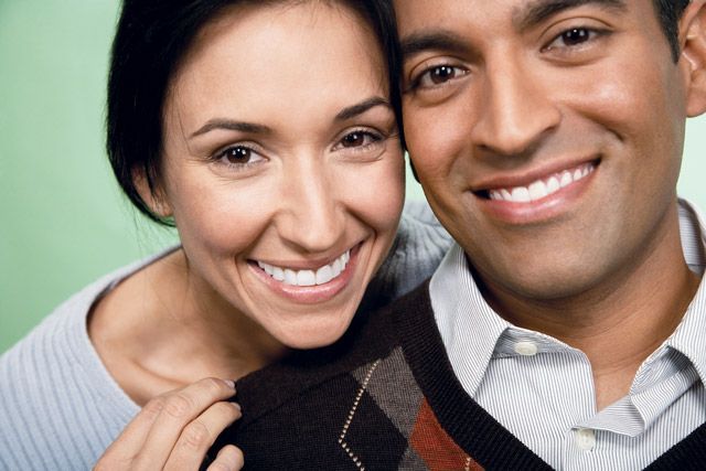 A man and a woman are smiling for the camera.