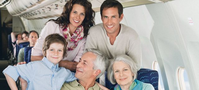 A family is posing for a picture on an airplane.